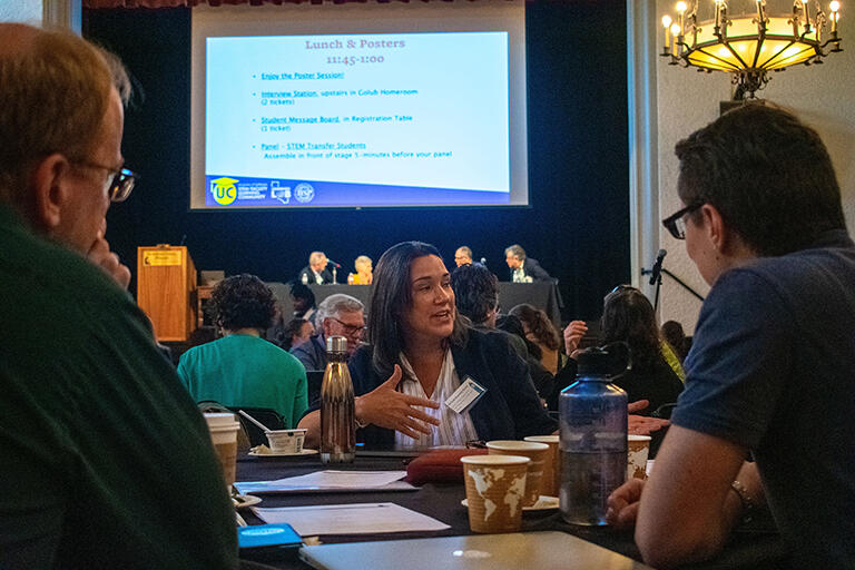 People sitting at a round table talking to one another