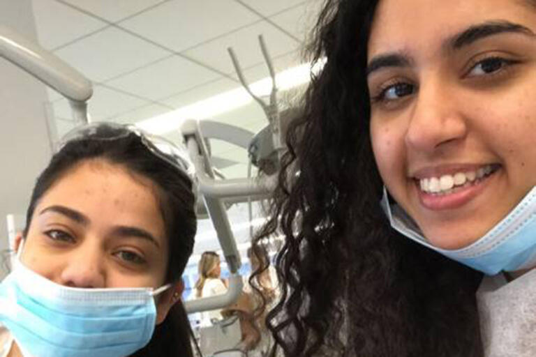 A selfie of two BSP members wearing blue hospital scrubs and face masks.