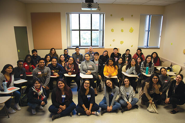 A large group of students posing for a photo inside a classroom
